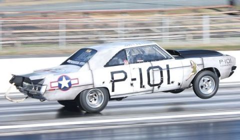 1992 Ford Mustang - A drag car with P-101 markings and an air force star emblem is captured mid-race on a track.