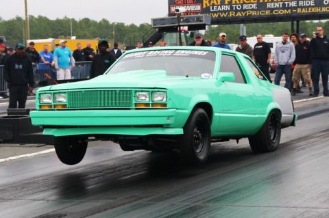 1992 Ford Mustang - Mint green drag car with a hood scoop launches off the line, front wheels lifting off the asphalt.