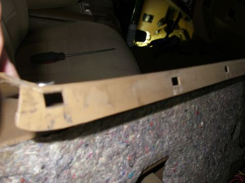 1990 Ford Bronco - A tan plastic trim piece is shown in the foreground, with a screwdriver resting on a car seat behind it.