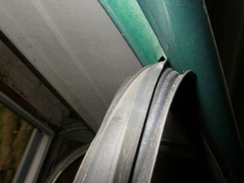 1990 Ford Bronco - Door seal weatherstripping, likely from a vehicle, attached to a painted surface.
