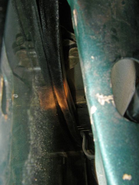 1990 Ford Bronco - A close-up view of the door seal and surrounding metal frame of a vehicle.