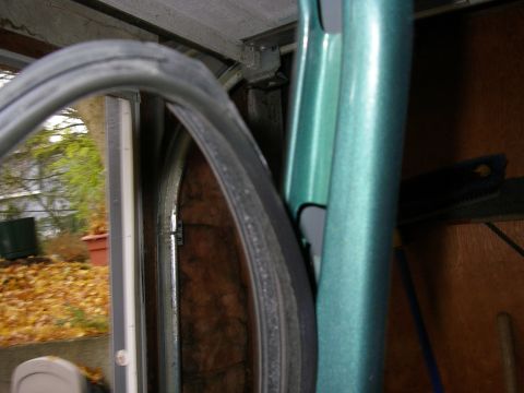 1990 Ford Bronco - Close-up of weatherstripping on the door frame of a green vehicle.