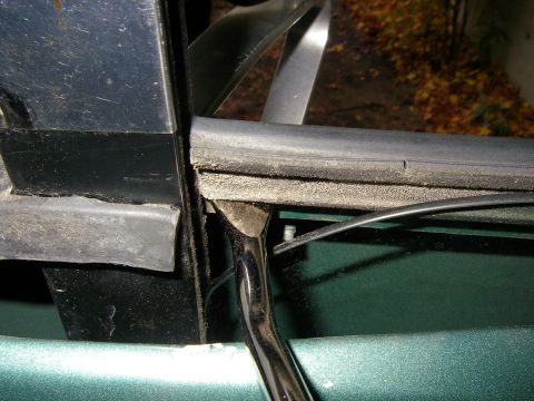 1990 Ford Bronco - Removing worn door seal from a vehicle's frame, revealing dust and debris underneath.