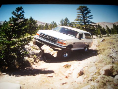 1996 Ford Bronco - This 1996 Ford Bronco is shown tackling a challenging off-road course in a mountainous, wooded area.