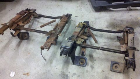 2005 Ford F-250 - Two sets of rusty seat frames are shown on a concrete floor, likely for a truck.