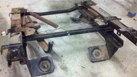 2005 Ford F-250 - Seat frame assembly with springs and mounting brackets is shown on a concrete floor.