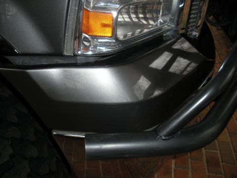 2005 Ford F-250 - Close-up of the front bumper and headlight assembly on a dark gray truck, consistent with a 2005 Ford F-250.