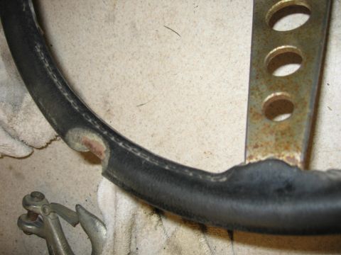 2005 Ford F-250 - Close-up of a damaged steering wheel, showing wear and tear on the leather grip and rusted metal components.