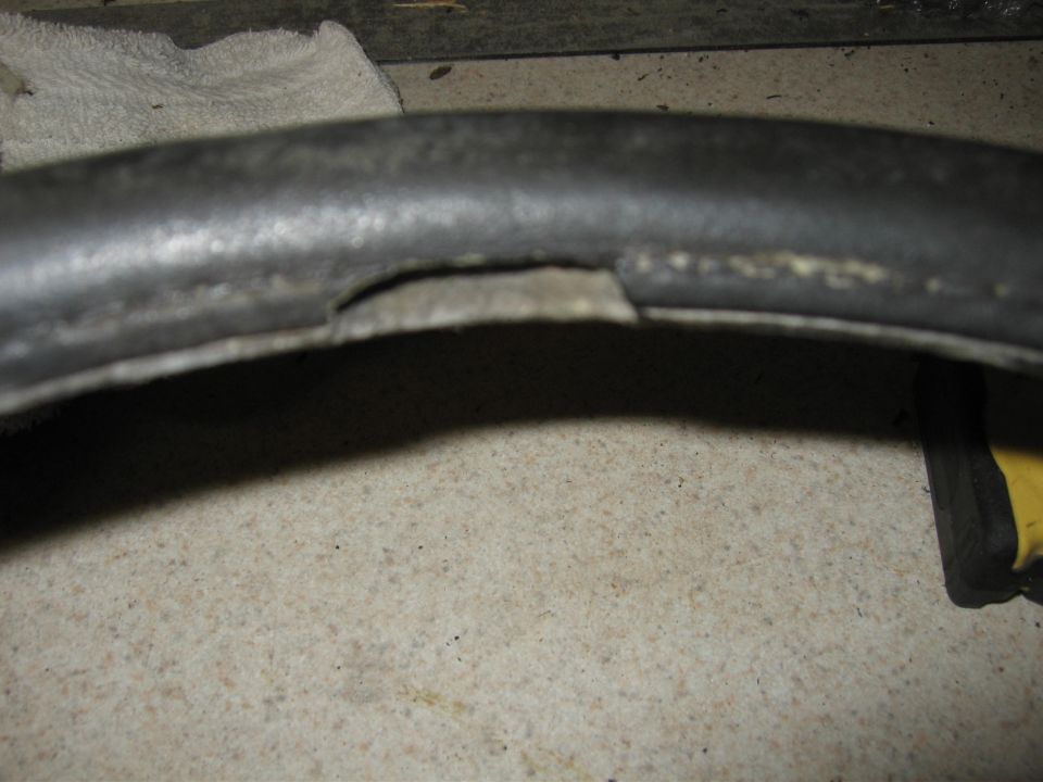 Black rubber hose with a lengthwise split on a speckled surface