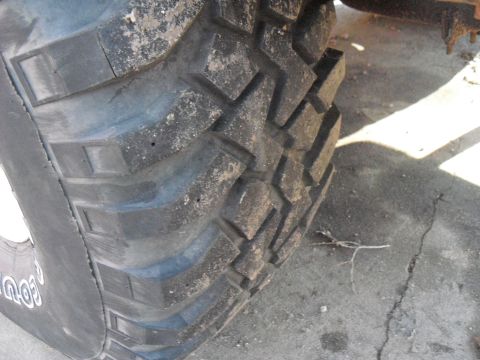 1986 Ford Bronco - A close-up of a vehicle's tire tread shows dirt and wear.
