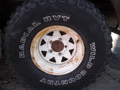 1986 Ford Bronco - This image shows a close-up of a tire and wheel, with visible text indicating 'RADIAL RVT WILD COUNTRY'.