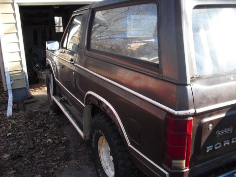 1986 Ford Bronco - This 1986 Ford Bronco is parked in a garage, showing its rear quarter panel and side profile.