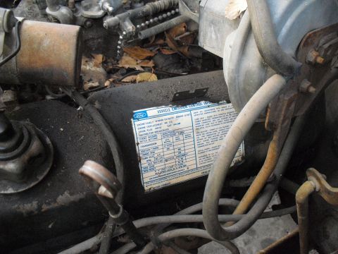 1986 Ford Bronco - A close-up view of an engine bay, focusing on a vehicle emission control information sticker.