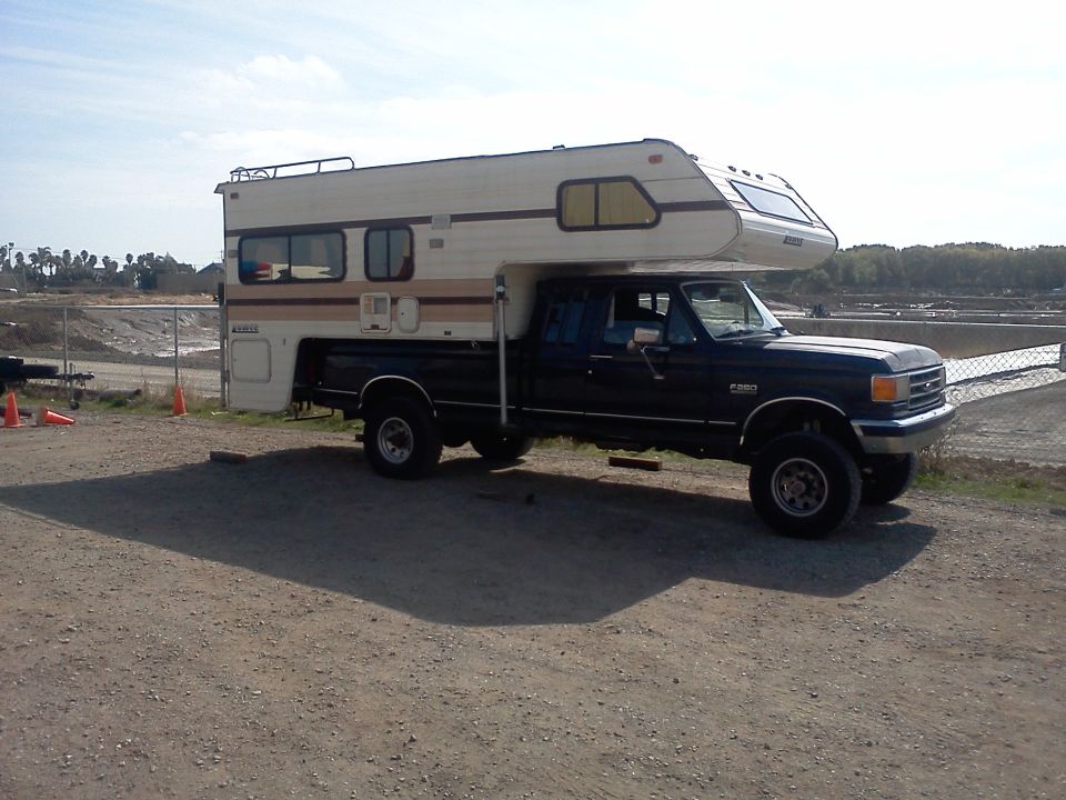 1991 Ford F-350 truck with a camper shell on the bed, side view