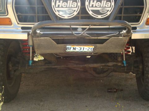 1991 Ford Bronco - Close-up view of the front bumper, suspension, and Hella lights on an off-road vehicle.