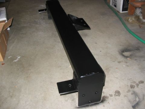 1995 Ford Bronco - A black metal bumper with mounting brackets is shown on a concrete floor.
