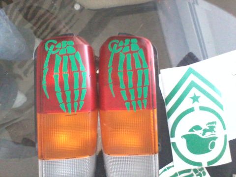 1998 Jeep Cherokee - Taillights adorned with green skeleton hand decals are shown next to a sticker with military insignia.