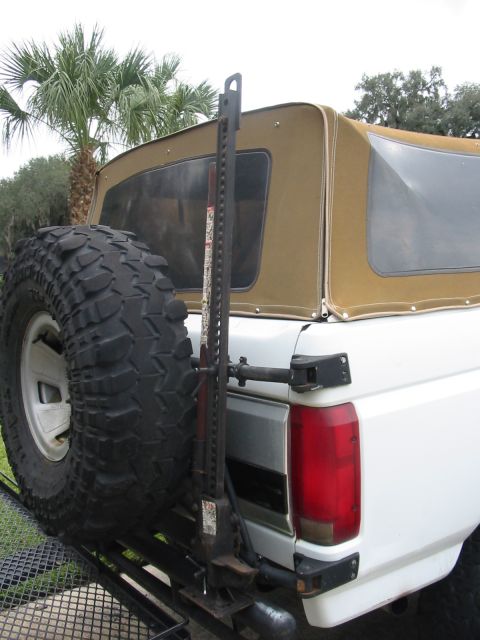 1992 Ford Bronco - Rear view of a 1992 Ford Bronco showing the spare tire and a Hi-Lift jack mounted on the carrier.