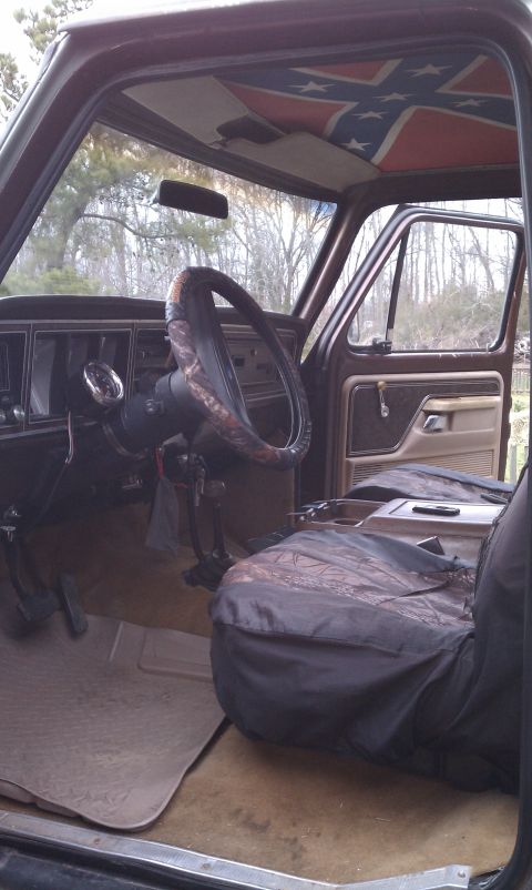 1979 Ford Bronco - Interior view of a 1979 Ford Bronco, a custom Confederate flag headliner and camouflage seat covers.