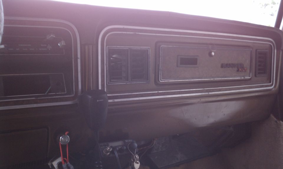 1979 Ford Bronco interior dashboard with wood grain trim, radio, and shifter