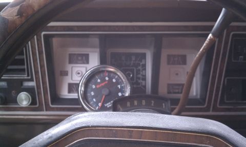1979 Ford Bronco - The interior of a 1979 Ford Bronco shows a tachometer and wood grain trim on the dashboard.