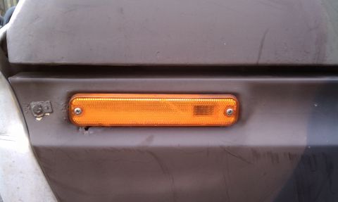 1979 Ford Bronco - The amber marker light is mounted on a section of the vehicle's exterior paneling.