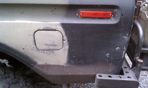 1979 Ford Bronco - This vehicle's rear quarter panel displays a camouflage paint scheme with visible rust and damage.