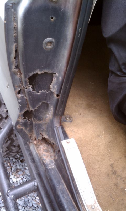 1979 Ford Bronco - The door frame shows extensive rust damage, compromising its structural integrity.