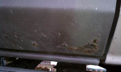 1979 Ford Bronco - This close-up shows significant rust and corrosion on the lower body panel of a vehicle.