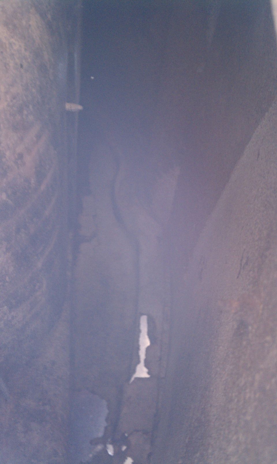 Close-up view of the underbody of a vehicle, showing frame rails and suspension components