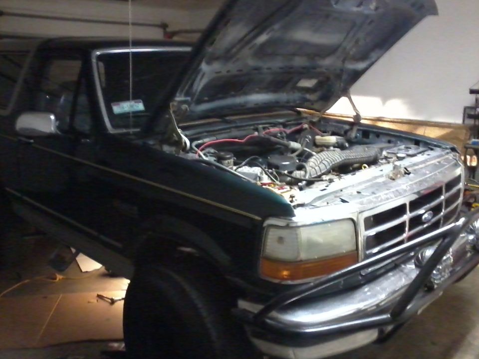 Green 1993 Ford Bronco front view, hood open, engine exposed
