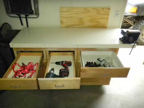 1997 Ford Ranger - A workbench holds various tools and supplies, with a vehicle partially visible in the background.