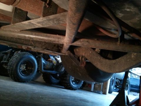1967 Ford Mustang - The photo shows the undercarriage of a vehicle, with other vehicles and tires visible in the background.