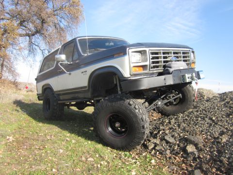 1985 Ford Bronco - This modified Ford Bronco features a raised suspension and aggressive off-road tires, ready for rough terrain.