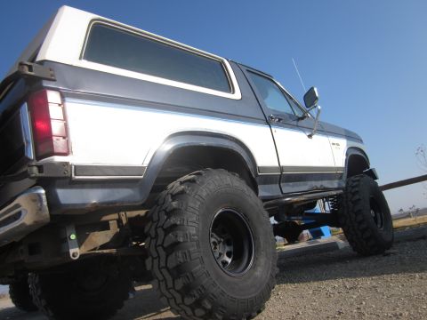 1985 Ford Bronco - This modified Ford Bronco sits high on large tires, indicating a custom build.