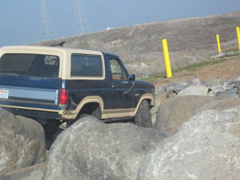 1985 Ford Bronco - This Ford Bronco is shown off-road, maneuvering through a rocky terrain.