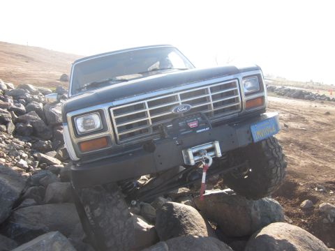 1985 Ford Bronco - This 1985 Ford Bronco is captured navigating a challenging rocky course, its off-road capabilities with a front-mounted winch.