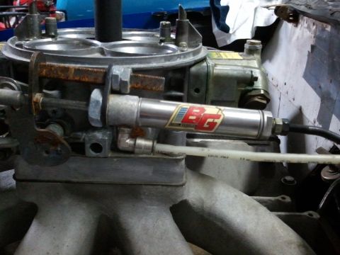 1967 Ford Mustang - A close-up view of a carburetor and associated fuel system components, including a BG nitrous oxide system part.