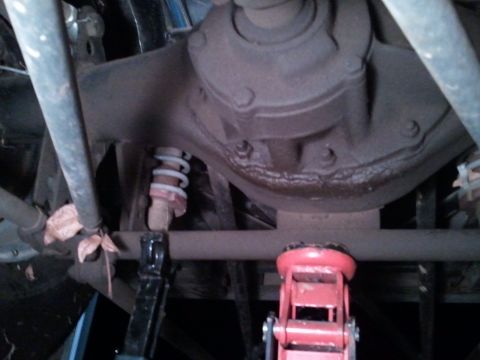 1967 Ford Mustang - The rear axle assembly and suspension components are visible, supported by a jack and jack stands.