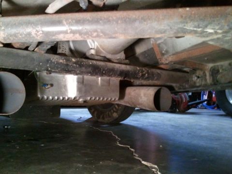 1967 Ford Mustang - A low-angle shot reveals the undercarriage of a vehicle, highlighting a custom oil pan and exhaust system.