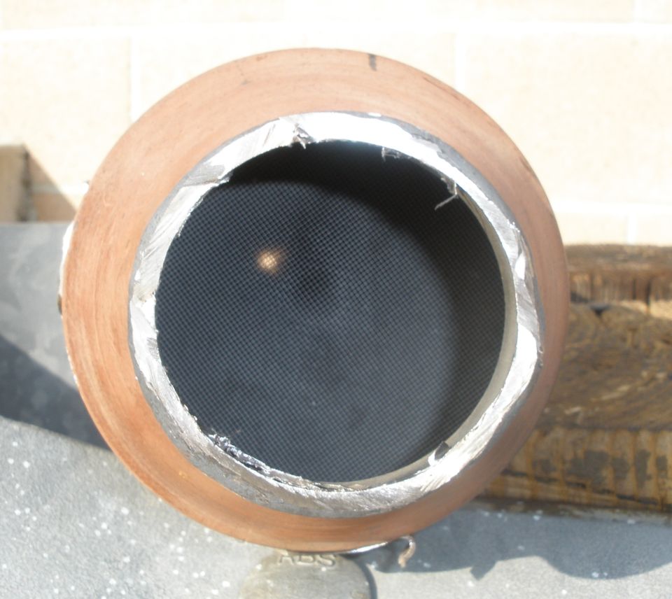 Close-up of a catalytic converter with a honeycomb interior and metal casing