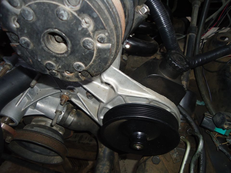 Engine water pump and pulley assembly with black hose and wiring