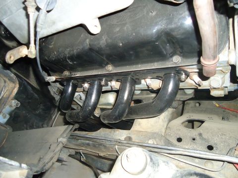 1987 Ford F-150 - Exhaust manifold pipes attached to the engine block of a vehicle.