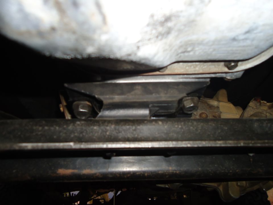 Underside view of a vehicle's frame and some mechanical components, possibly a transmission mount