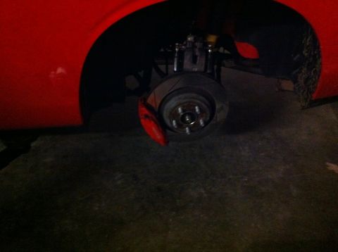 2010 Dodge Challenger - Close-up of a car's brake system with the wheel off, revealing the rotor and caliper.