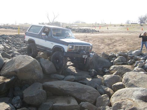 1985 Ford Bronco - This Ford Bronco is shown navigating a challenging rocky terrain, demonstrating its off-road capabilities.