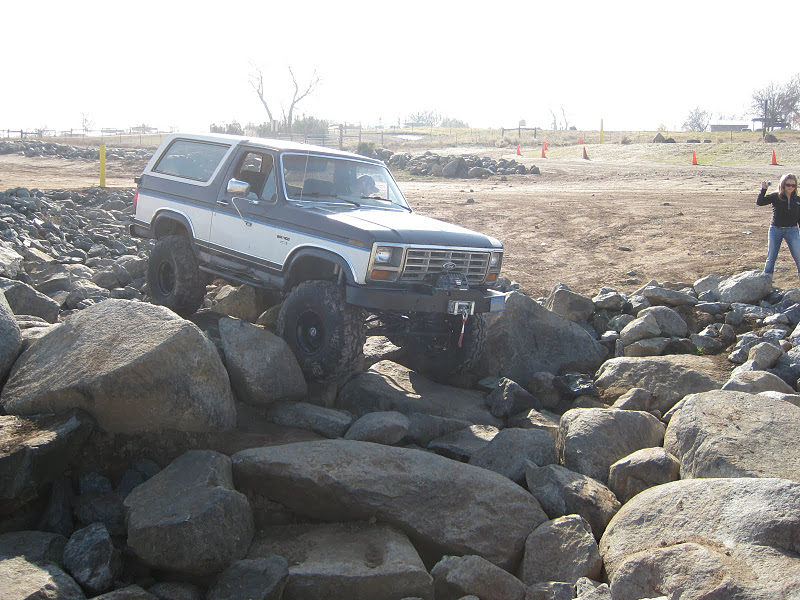 Two-tone Ford Bronco navigating a rocky trail