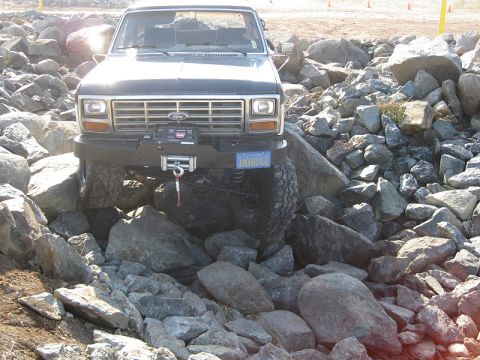 1985 Ford Bronco - This 1985 Ford Bronco is shown off-road, navigating a challenging rocky obstacle course.