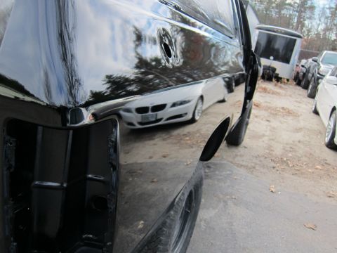 1987 Dodge 1500 - Reflection of a white car is visible on the glossy side panel of a black truck.