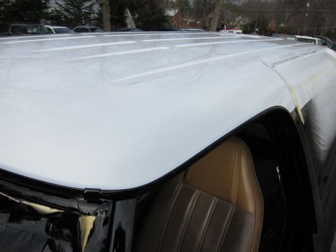 1987 Dodge 1500 - Close-up view of the white roof and tan interior of a vehicle, with other vehicles visible in the background.